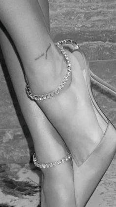 black and white photo of woman's feet with ankle chains