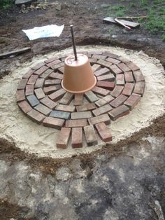 a small bell sitting on top of a brick fire pit