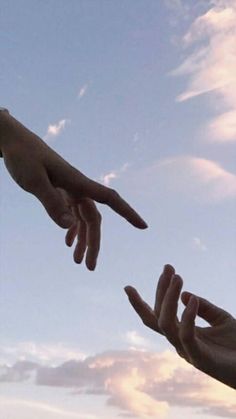 two hands reaching out towards each other in the sky