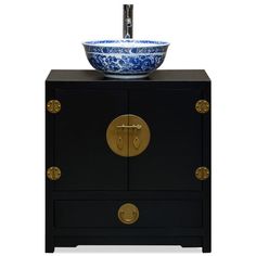 a black cabinet with a blue and white bowl on it's top, sitting next to a faucet