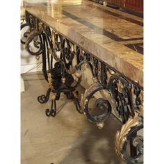 an ornately designed marble table with wrought iron work on the top and bottom edge