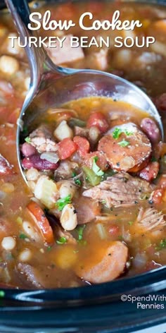 a spoon full of soup in a crock pot with meat and beans on top