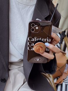 a woman holding a cell phone in her hand with a cappuccino sticker on it