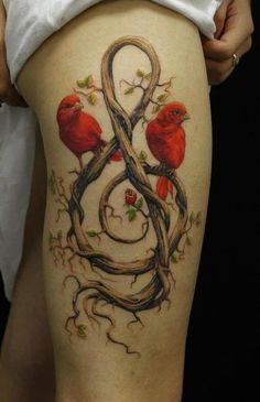 a woman's thigh with tattoos on it and two birds sitting on the letters