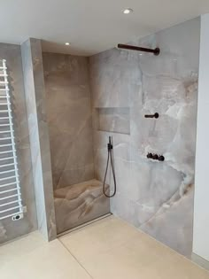 a walk in shower sitting next to a white radiator and wall mounted heater