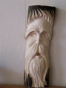 a wooden carving of an old man's face on a shelf next to a wall