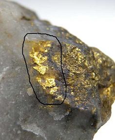 a rock with gold flakes on it and a black line drawn across the top