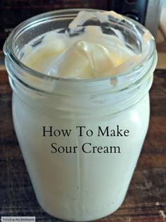 a jar filled with sour cream sitting on top of a wooden table