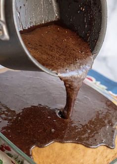 a person pouring chocolate into a pan