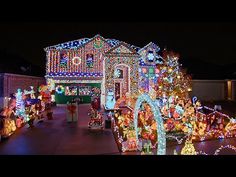 a house covered in christmas lights with lots of decorations on the front and side of it