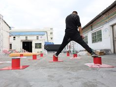 a man in black shirt jumping over red cones