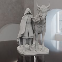 a statue of a man standing next to a white bull with horns and a cloak on it's head