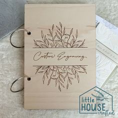 a wooden wedding guest book with the words, cotton & spring written on it and two keychains