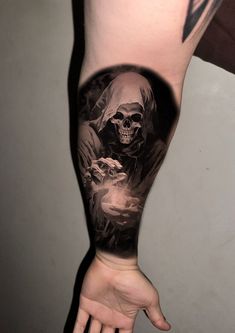 a man's arm with a tattoo on it and a skull in the middle