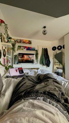 a laptop computer sitting on top of a bed in a room with lots of plants