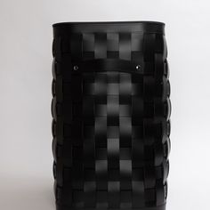 a large black basket sitting on top of a white table