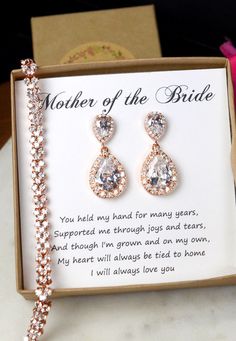 the mother of the bride earrings are set in a box with a card on it