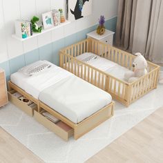 two wooden cribs with mattresses and drawers in a child's room