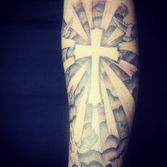 a man with a cross tattoo on his arm