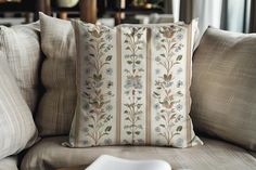 a close up of a pillow on a couch with a book in the foreground