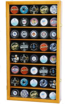 a wooden display case filled with lots of different types of hockey pucks on it