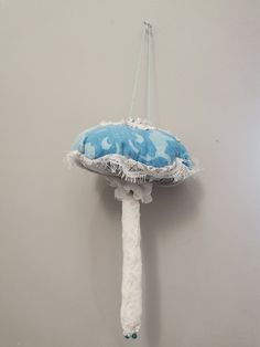 a blue and white umbrella hanging from a hook on a gray wall in a room