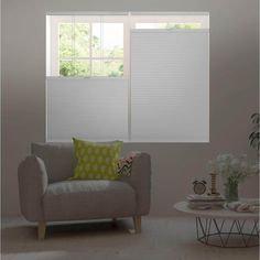 a living room filled with furniture and windows covered in white cellular shade coverings on the windows