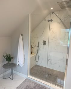 a bathroom with a walk in shower next to a white sink and toilet under a skylight