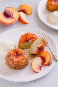 a white plate topped with two pieces of cake next to ice cream and sliced peaches