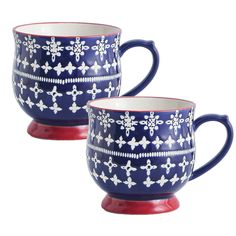 two blue and white coffee mugs with snowflakes painted on them, one is red