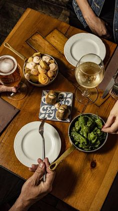 two people are eating at a table with plates and bowls of food in front of them