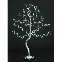 a wire tree sculpture is shown on a black background