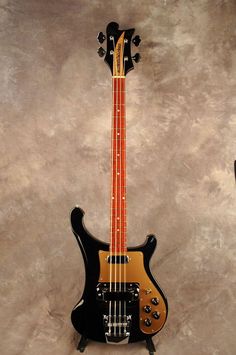 a black and gold electric guitar sitting on top of a table next to a wall