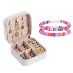 an open white box with bracelets and rings in it next to a set of jewelry