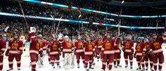 a group of men in red and yellow uniforms standing on top of an ice rink