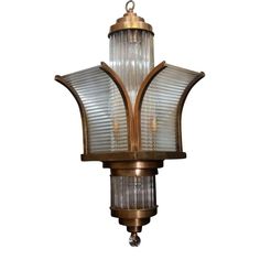 an old fashioned light fixture with glass shades on the top and bottom half of it