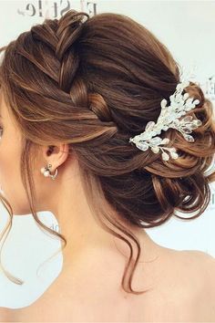 a woman wearing a wedding hair comb with flowers on it's head and pearls in her hair