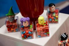 small plastic containers filled with candy sitting on top of a table