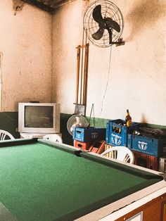 a pool table with a television and fan in the corner next to an air conditioner