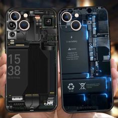 two hands holding up cell phones that have been taken apart