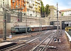 a train traveling down tracks next to tall buildings