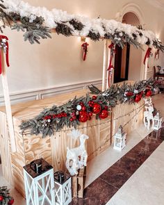 christmas decorations are hanging on the side of a wooden wall in a room with white and red decor