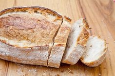 a sliced loaf of bread sitting on top of a wooden table next to a knife