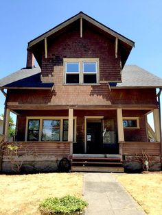 a large brown house sitting on top of a grass covered field