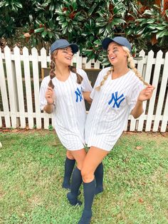 two women in baseball uniforms posing for the camera