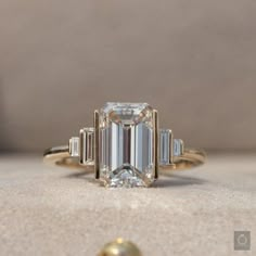 an emerald cut diamond ring with three baguets