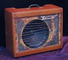 an old amp sitting on top of a purple cloth