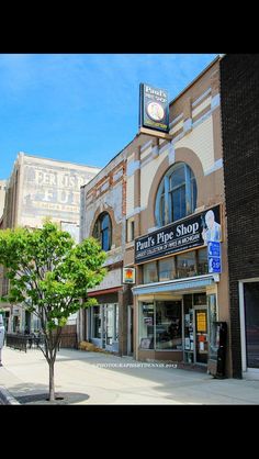 an empty city street with shops and stores on the side walk in front of it