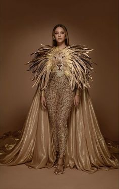 a woman in gold and black outfit with feathers on her shoulders