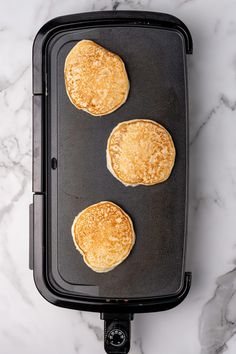 three pancakes on a baking sheet ready to go into the oven, with one being cooked